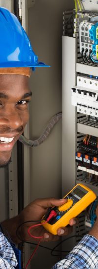 Technician Examining Fusebox With Multimeter Probe