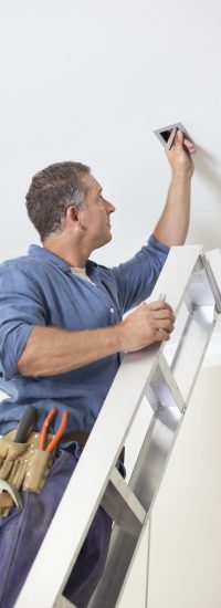 Electrician working on ceiling lights